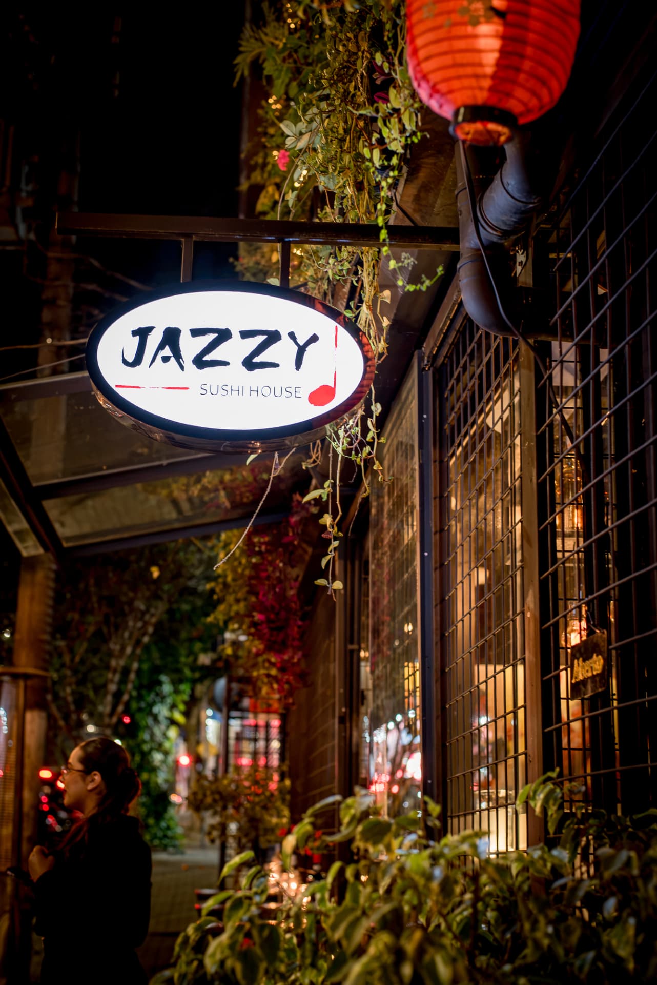 Fachada noturna com o letreiro iluminado do Jazzy